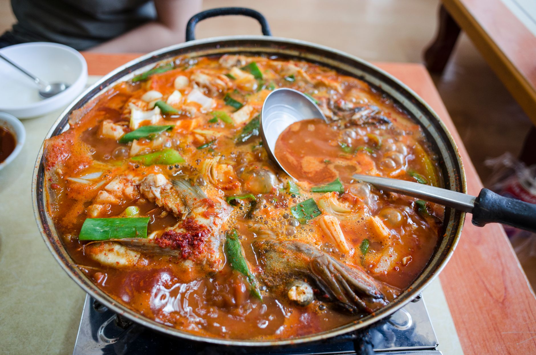 Budae-jjigae simmering with SPAM, tofu, kimchi, noodles, and melted cheese