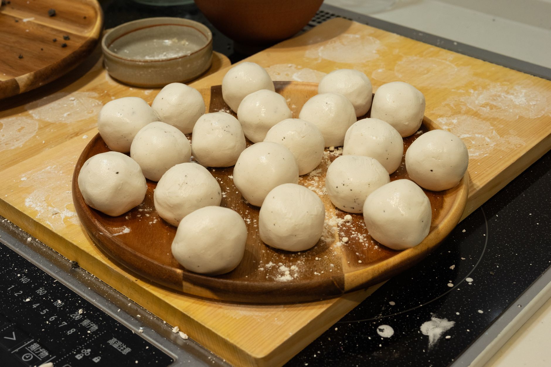 Freshly made songpyeon (Korean half-moon rice cakes) with sesame filling on a ceramic plate